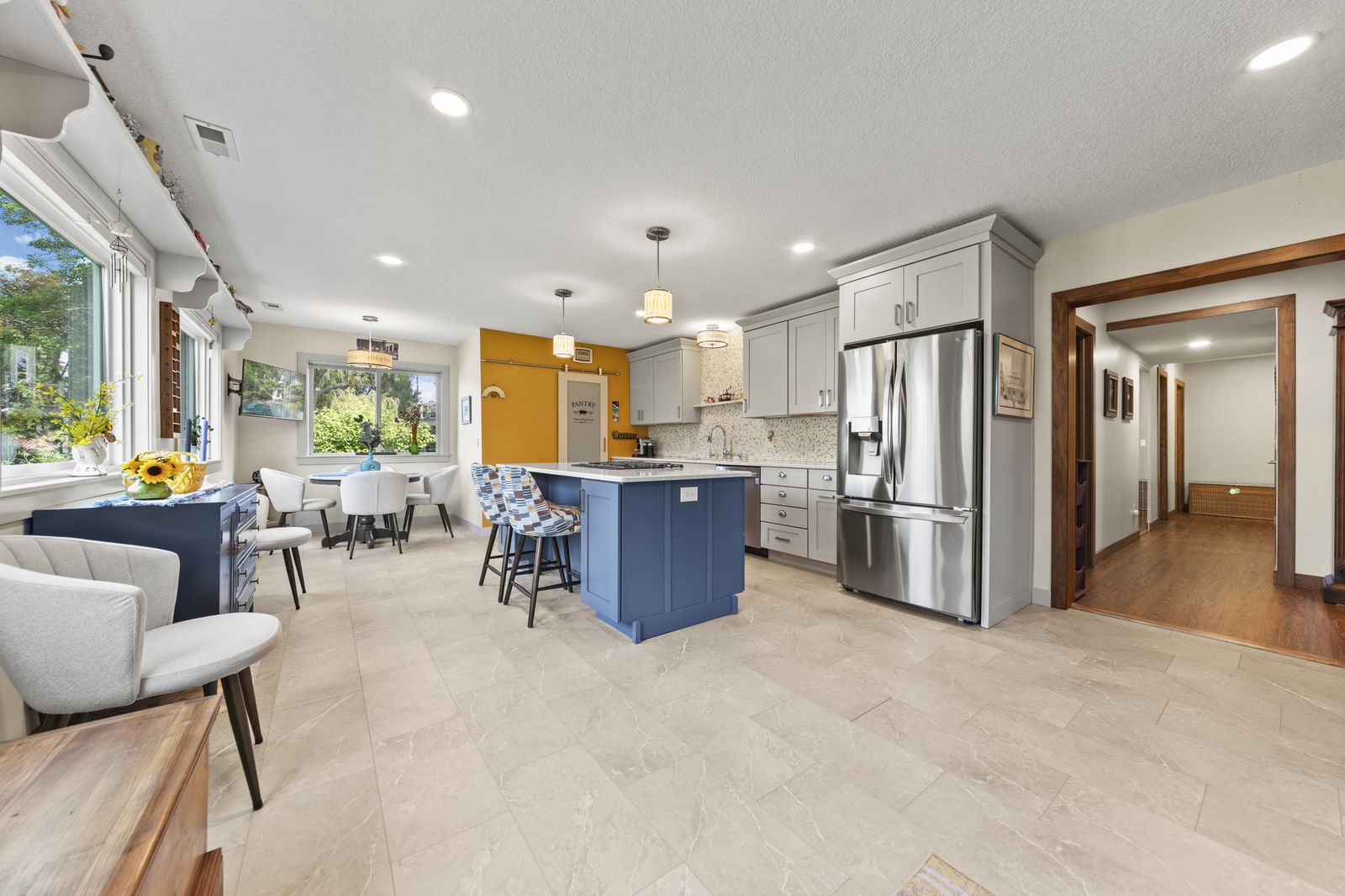 Kitchen with stainless steel refrigerator and hallway view