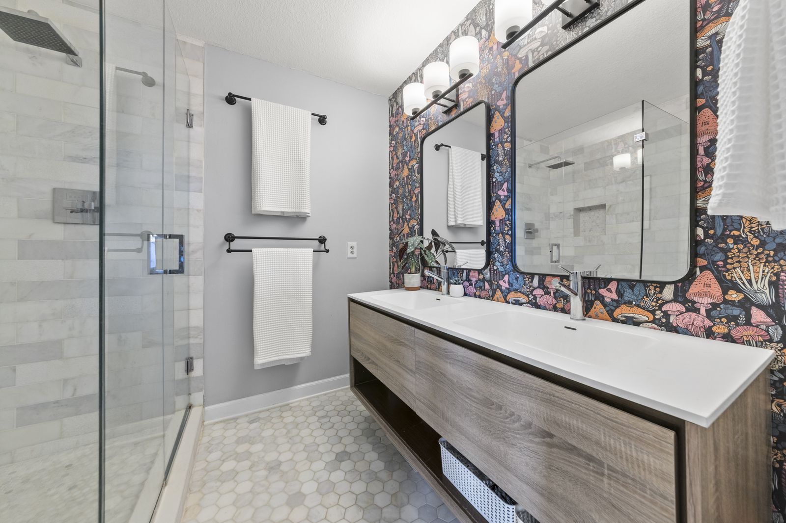 Bathroom with glass shower and patterned wallpaper