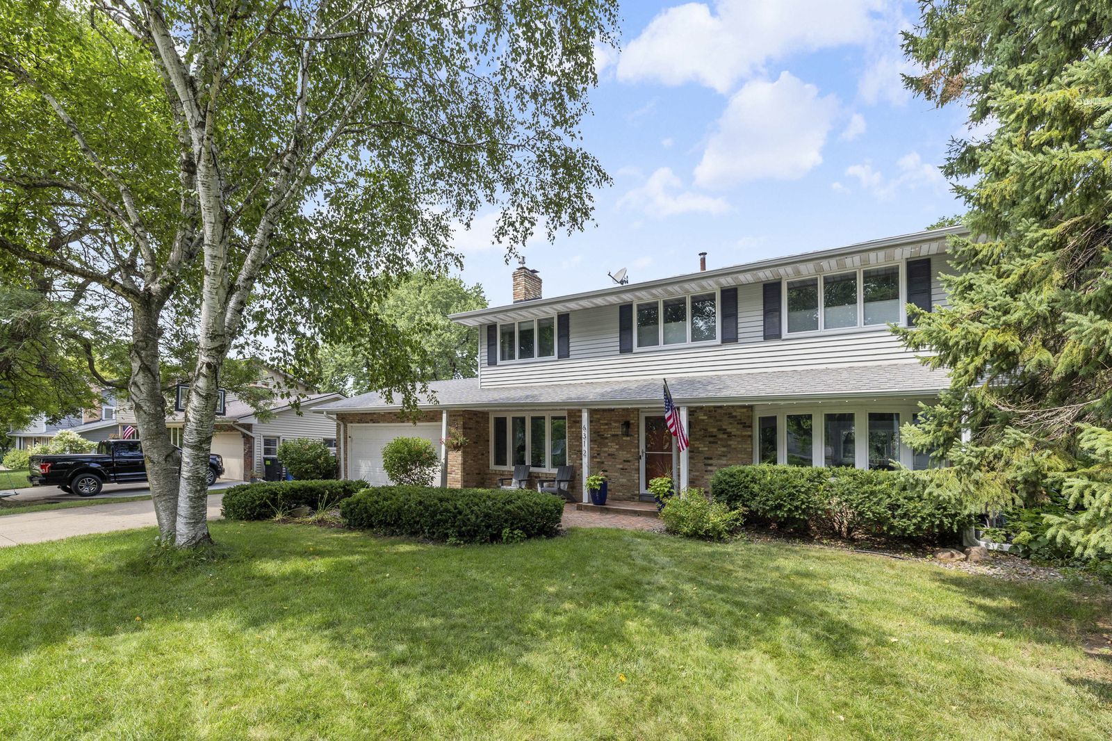 Front exterior of house with American flag and landscaping