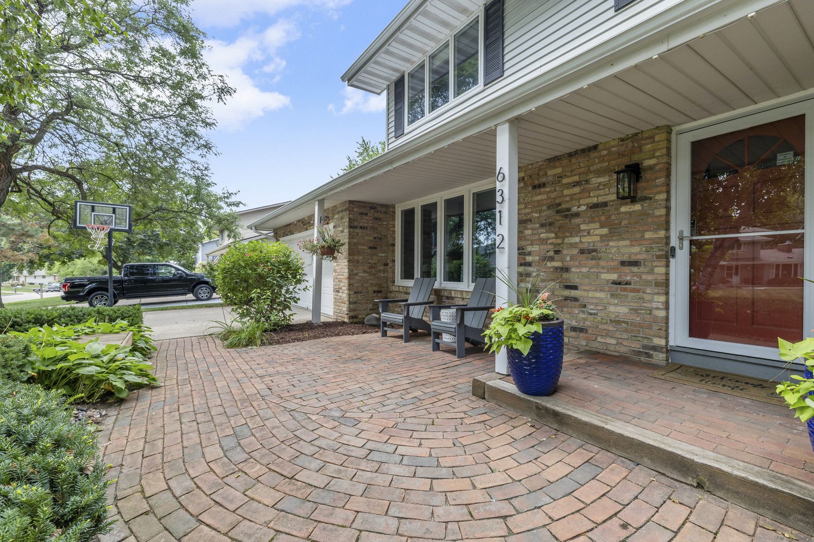 Front entrance with brick paver walkway and porch