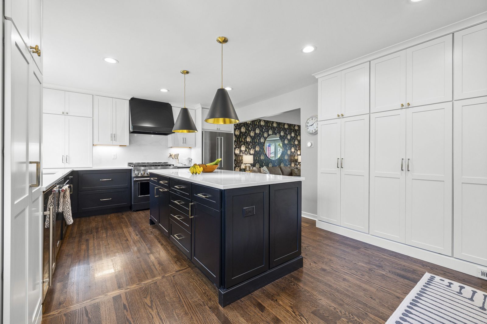 Kitchen with white cabinetry and dark island