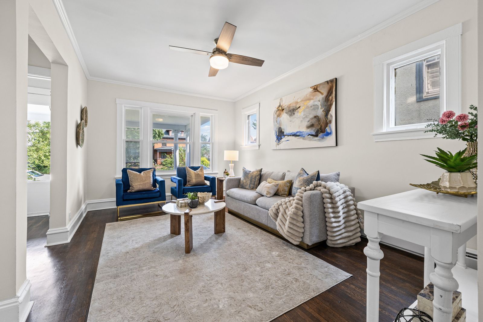 Living room with ceiling fan and blue armchairs