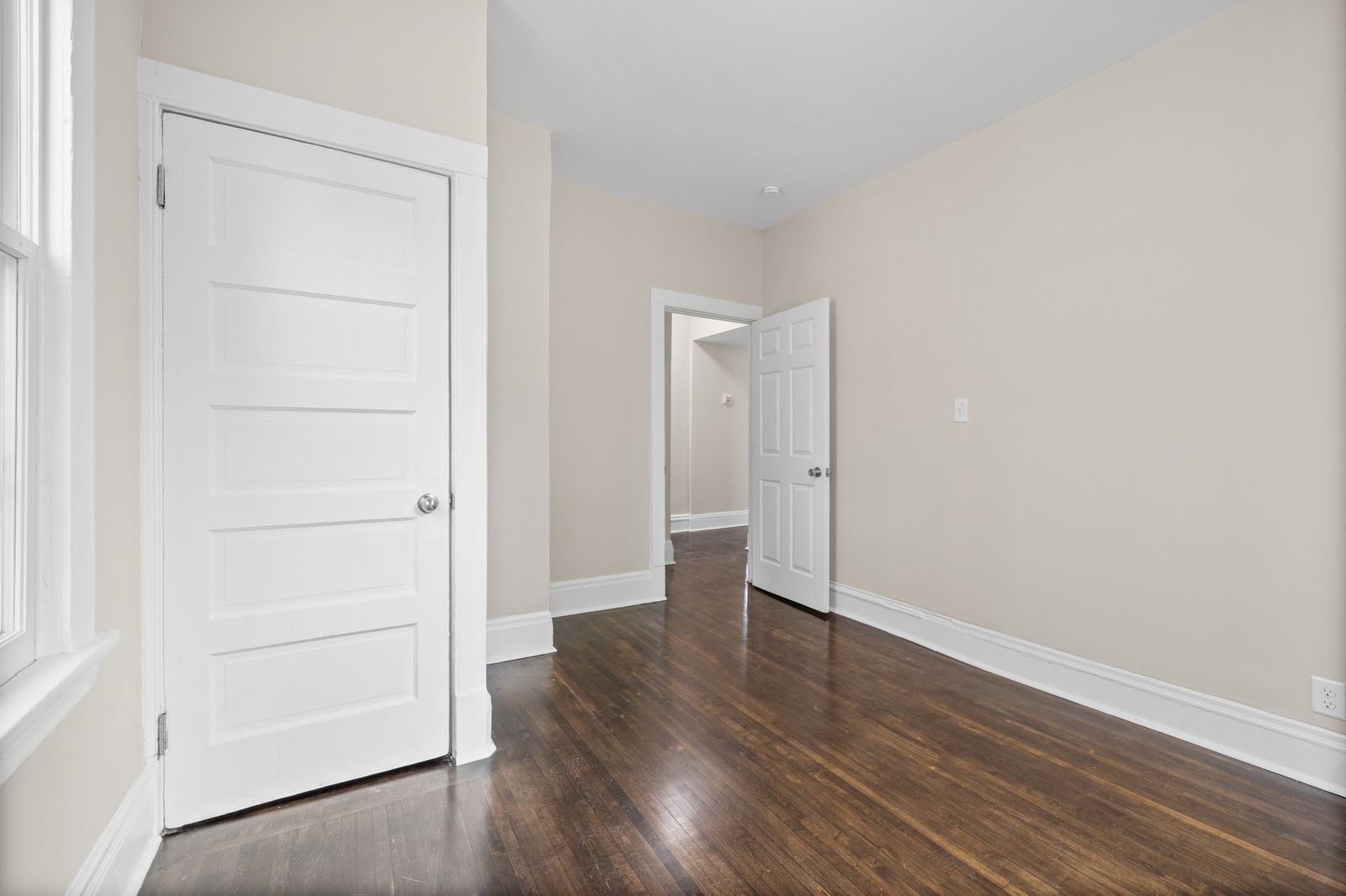 Empty upstairs room with hardwood floors and open door