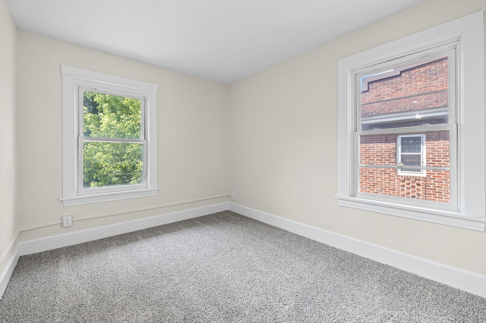 Upstairs bedroom with window overlooking neighborhood